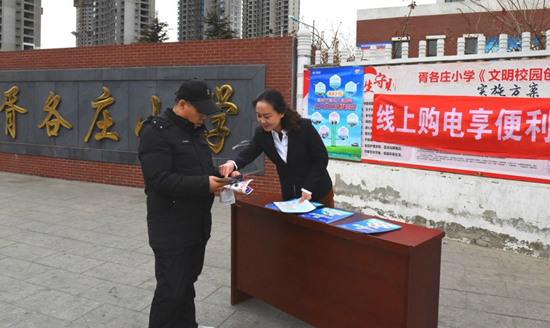 冀北唐山市丰南区供电公司志愿者在到胥各庄小学门前开在线上电费宣传活动